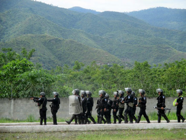 Riot police fire tear gas as they advance to evict a road blockade set up by fishers protesting mining pollution in El Estor, Guatemala. (Photo: Sandra Cuffe)