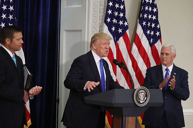 US President Donald Trump (center) speaks while flanked by Kansas Secretary of State, Kris Kobach (Left) and US Vice President Mike Pence during the first meeting of the Presidential Advisory Commission on Election Integrity in the Eisenhower Executive Office Building, on July 19, 2017 in Washington, DC. (Photo: Mark Wilson / Getty Images)