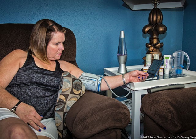 Kellie Taub monitoring her blood pressure and pulse, which she does several times a day due to her rapid heartbeat, at her home in Reserve, Louisiana. (Photo: Julie Dermansky)