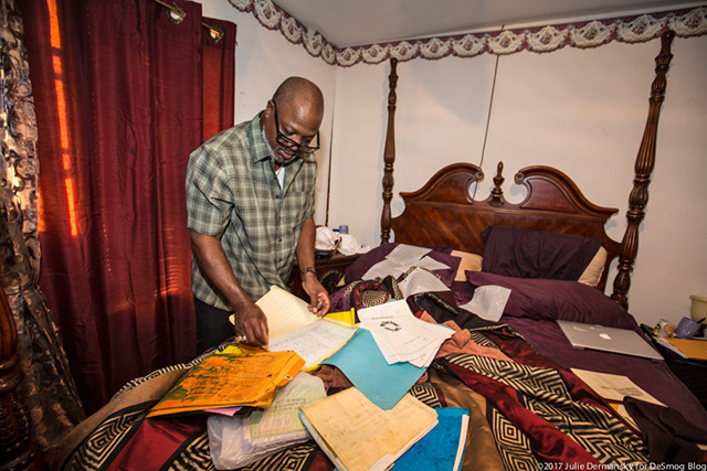 Hilton Kelley tries to separate papers important to him, including plays and poems he wrote, which were soaked in the flood. (Photo: Julie Dermansky)