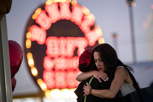 Las Vegas resident Elisabeth Apcar (right) hugs a woman who was working at the concert venue on Sunday night (she wished to remain anonymous), at a makeshift memorial at the northern end of the Las Vegas Strip, October 4, 2017 in Las Vegas, Nevada. (Photo: Drew Angerer / Getty Images)