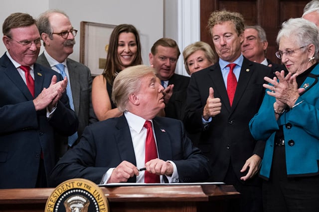 President Donald Trump hands a pen that he used to sign an executive order on health care to Sen. Rand Paul in the Roosevelt Room at the White House in Washington, DC on Thursday, October 12, 2017. (Photo: Jabin Botsford / The Washington Post via Getty Images)