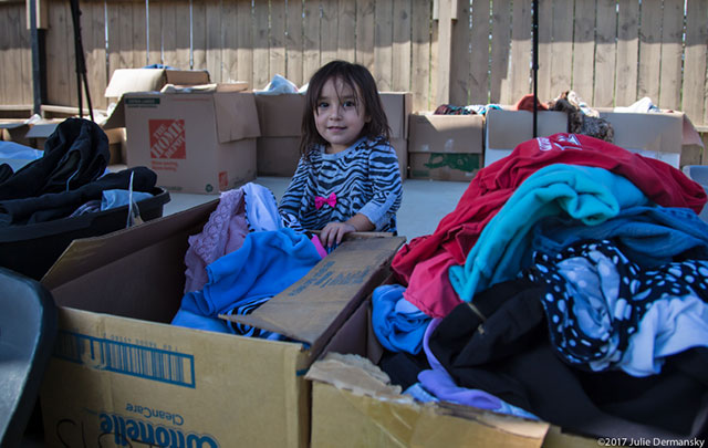 A young storm victim gathers donated supplies at a makeshift relief center in the driveway of Kelley’s Kitchen. (Photo: Julie Dermansky)