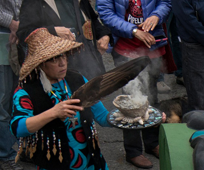 A Lummi woman burns sage. (Photo: Neal Anderson)