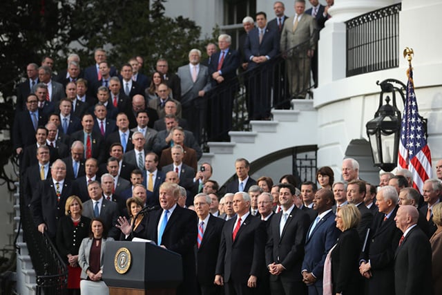 Donald Trump, flanked by Republican lawmakers, celebrates Congress passing the Tax Cuts and Jobs Act on the South Lawn of the White House on December 20, 2017 in Washington, DC. The tax bill is the first major legislative victory for the GOP-controlled Congress and Trump since he took office almost one year ago. (Photo: Chip Somodevilla / Getty Images)
