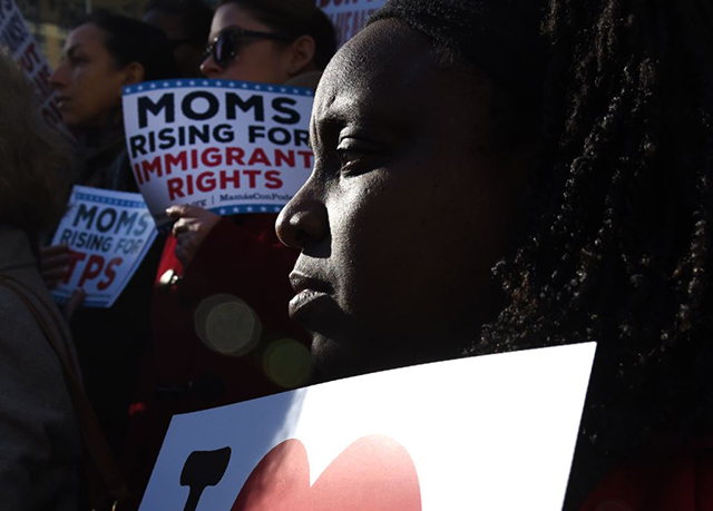 Immigrant advocates display signs during a rally to protest the decision from Trump's Department of Homeland Security to terminate Temporary Protected Status for over 50,000 refugees from Haiti on November 21, 2017, in New York City. (Photo: TIMOTHY A. CLARY / AFP / Getty Images)