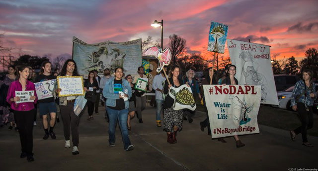 Opponents of the Bayou Bridge pipeline, a project proposed by Energy Transfer Partners that would be the tail end of the Dakota Access network, walk toward the entrance of Louisiana’s environmental permit hearing on February 8.