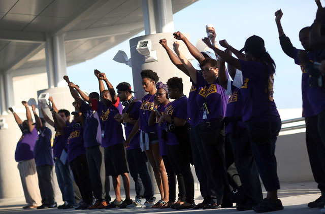 Workers stand together as they strike at the Fort Lauderdale-Hollywood Airport to protest what they say are repeat labor violations by airline contractors, G2 Secure Staff and Eulen America, that are preventing employees from organizing to improve poverty wages and poor working conditions on September 1, 2015. in Fort Lauderdale, Florida. (Photo: Joe Raedle / Getty Images) 