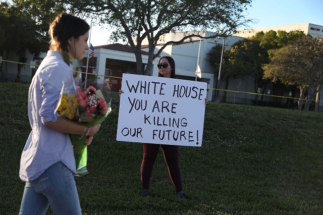  Karissa Saenz, a senior at Marjory Stoneman Douglas High School, holds a sign that reads, ' White House You are Killing Our Future!,' on February 18, 2018 in Parkland, Florida. Police arrested and charged 19 year old former student Nikolas Cruz for the February 14 shooting that killed 17 people. (Photo by Joe Raedle/Getty Images)