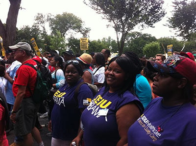 Lakesia Collins, center, a nursing assistant from Chicago, joins the anniversary March on Washington.