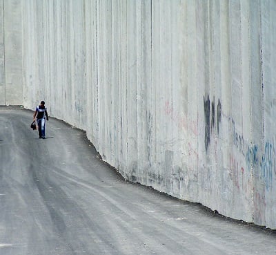 The wall built by Israel in Abu Dis, an Arab a neighborhood in East Jerusalem. It divides Abu Dis into two. The wall is a means of occupying land from Palestinians. (Photo: <a https://www.flickr.com/photos/67182041@N00/26336780/in/photolist-3jZ1q-3jZ1t-3jYw4-3jYw5-3jZ1u-3jYw1-3jYw2-3jYw3-3jYvZ-3jXs8-3jZUz-3jZJ8-3jZJa-3jZJ9-8ayaj8-j9SpH-8pABqd-7qAF9x-DZVQf-5mE6i-NdpVz-8eb8q2-6GvJth-8QvyKu-Q6uhQ-Q6uhJ-3qwXF-8pWviB-de84N-88yFjs-8QsCin-8QvMjW-8QvJsd-8QsGxn-8QvLAN-8QvEtJ-8QsCNc-8QvJH3-5ffqEu-de84V-avrH25-nobs-87LsdM-aw5wjG-iNBpN-jSrEz-49F4w-7GYPKZ-69biBQ-89w7fv-89w7CZ