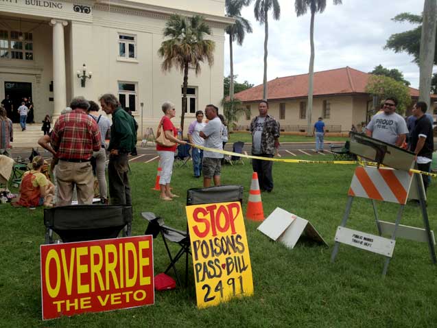 A Bill 2491 supporter talks with an agricultural worker opposed to the bill over a police partition set up to divide supporters from opponents at the county council meeting. The partition was later taken down due to concerns that the controversy was dividing the community. (Photo: Mike Ludwig / Truthout)