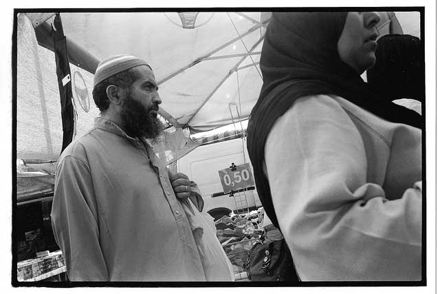 Middle Eastern immigrant and his wife in Portaportese market. (Photo: David Bacon)