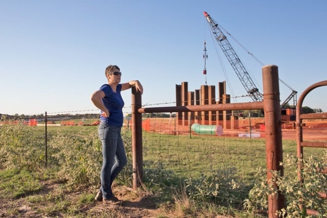 Julia Trigg Crawford peers into a TransCanada construction site adjacent to her land. (Photo: ©2013 Julie Dermansky)