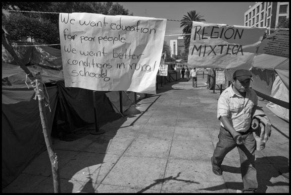 A striking teacher walks through the teachers' encampment, or planton, in the Plaza de la Republica. Left-wing teachers, members of the National Coordinadora of Education Workers, have been living here in protest of education changes that would impose standardized testing, like that in the United States. The region Mixteca is part of the state of Oaxaca, which has the largest union of radical teachers in the country.