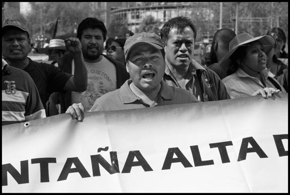 A striking teacher from the state of Guerrero wears a red star on his cap as he walks behind the banner in the teachers' march against education reform on the 20th anniversary of the North American Free Trade Agreement.