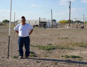 Hector Rodriguez stands next to a stake that workers from Linn Energy drove into the middle of his property. It marks the spot where there may one day be a fracked well. (Credit: Anna Simonton)