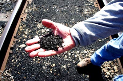 Petcoke covers the railroad tracks that are a border between the backyards of Southeast Side, Chicago families and KCBX’s terminal. (Credit Anna Simonton)