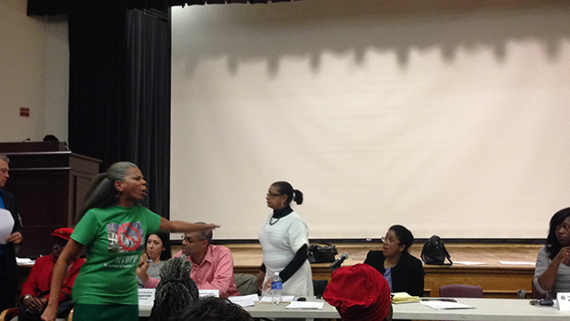 Alicia Boyd (left) chastises executive members of CB9, including District Manager Pearl Miles (center, in white) at a November meeting convened by community board 9 for cutting off time for public comments after 15 minutes. (Photo: Aaron Cantu)