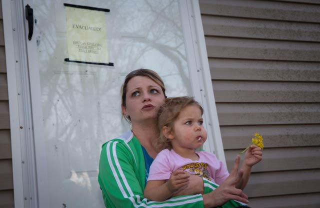 Jamie Weber with her daughter Ariana, in 2012 sitting on the steps of what is now her former home in Bayou Corne. (Photo: ©2015 Julie Dermansky)