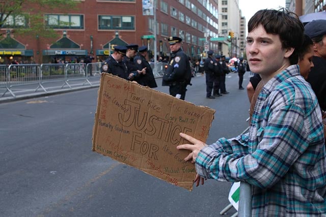 A protester leans over a police barricade along the march route near Union Square in Manhattan. (Photo: Matt Surrusco)