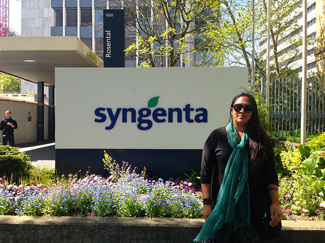 A security guard looks on as Hawaiian activist Malia Chun poses in front of Syngenta's global headquarters in Basel, Switzerland. (Photo: Mike Ludwig/Truthout)