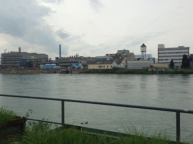 Old chemical and manufacturing buildings line the French banks of the Rhine River across from Basel, Switzerland. In 1986, a chemicals released during a fire and accidental spill in Basel contaminated the Rhine River, killing fish for hundreds of miles. (Photo: Mike Ludwig/Truthout) 