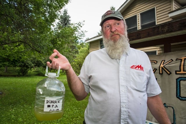 Ray Kem, a former industry worker in Dimock, PA, holds up water taken from his contaminated well. (Photo: Julie Dermansky)