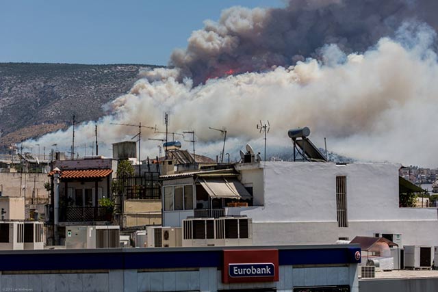 Forest fire in Athens, over the Eurobank logo, in July 2015.