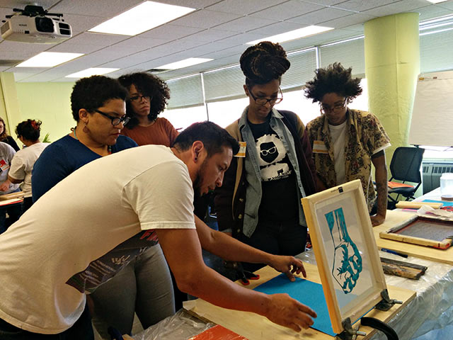 Remy demonstrates screen printing techniques at an early Rad Ed training in Chicago. (Photo: Kelly Hayes)