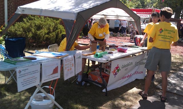 Eliza Carney works a table at NewWestFest. (Photo: ColoradoCareYES)