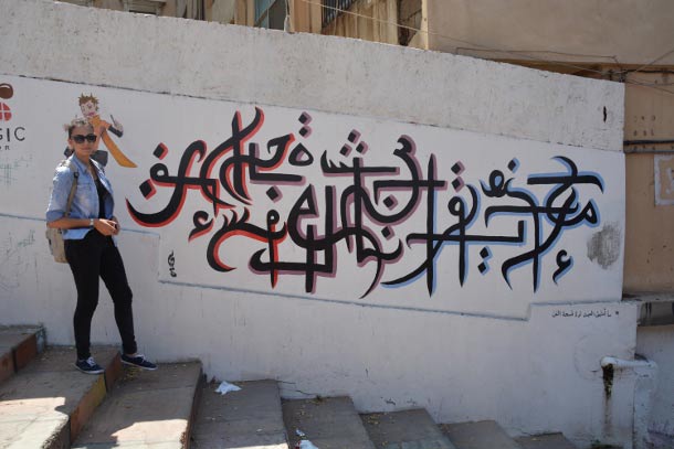 Hayat Chaaban stands next to one of her murals in Tripoli. (Photo: WNV / Christine Petré)