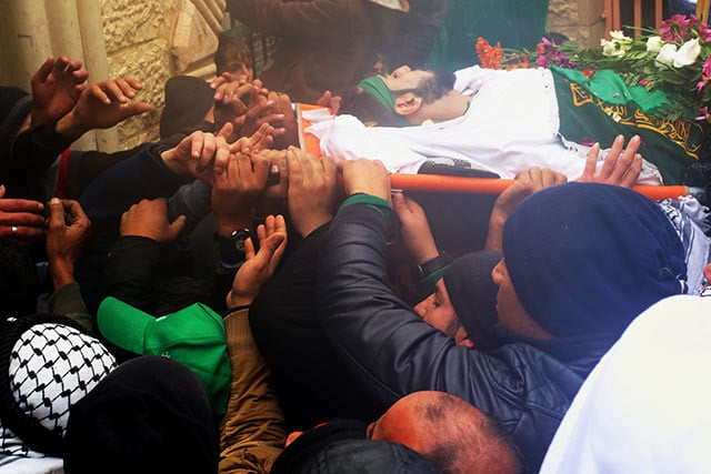 After the funeral prayers are completed, the bodies are carried into the Martyrs Cemetary, where they are buried in a joint burial. (Photo: Christian Peacemaker Teams)