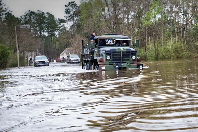 The National Guard sends a truck into Tallow Creek to rescue residents. (Photo: © 2016 Julie Dermansky)