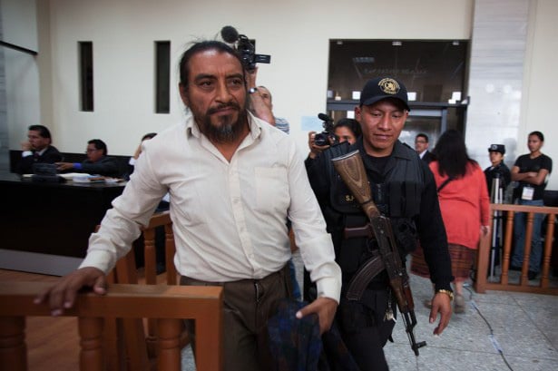 Rigoberto Juarez is escorted back to the holding cell within the court room in Guatemala City by an armed guard. (WNV / Jeff Abbott)