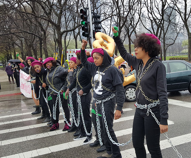 Protesters chain themselves together and raise their fists in a show of Black power. (Photo: Kelly Hayes)