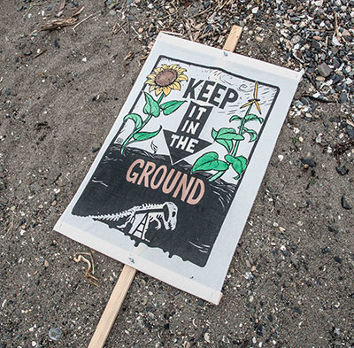 Keep it in the ground sign with image of sunflower and dinosaur. (Photo: Courtesy of Elliot Stoller)