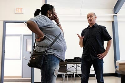 Lakisha Thompson speaks with Earthjustice attorney Chris Amato in the community room at Ezra Prentice Homes. Thompson's young cousins live at the apartments. (Photo: Earthjustice)