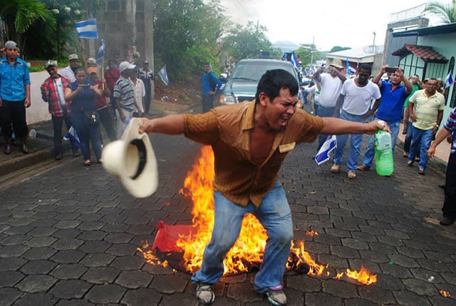 Campesinos burned a FSLN flag in response to the repression against the protesters, calling for a repeal of Law 840, which enables the expropriation of land throughout Nicaragua. (Photo: Rigo del Calvario López)