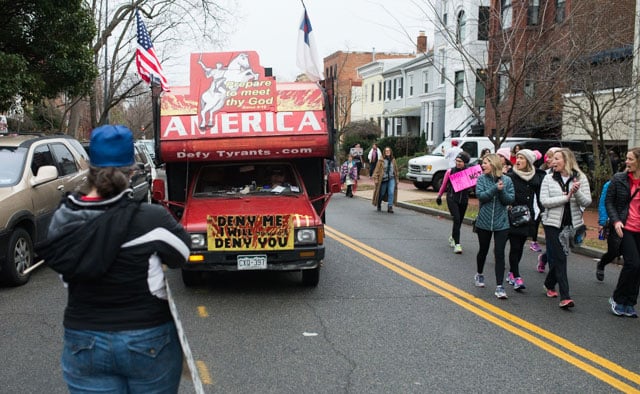 A truck plastered with religious and extreme anti-abortion views slowly follows Women's Marchers to the Capitol. (Photo: Zach Roberts) 