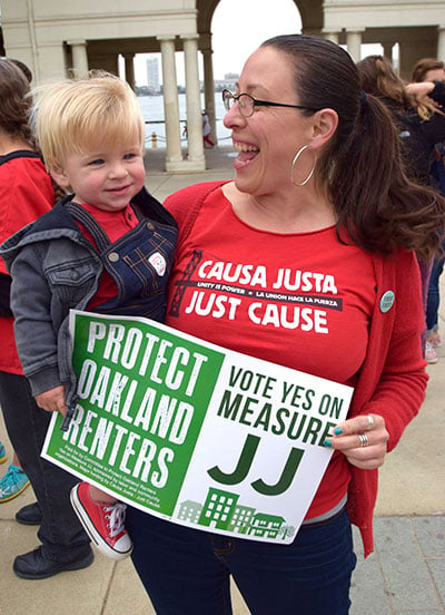 Maria Poblet raises awareness for Measure JJ — an Oakland renters protection ordinance that was voted into effect in November 2016 — near Oakland's Lake Merritt in October 2016. (Photo: Josh Warren White)