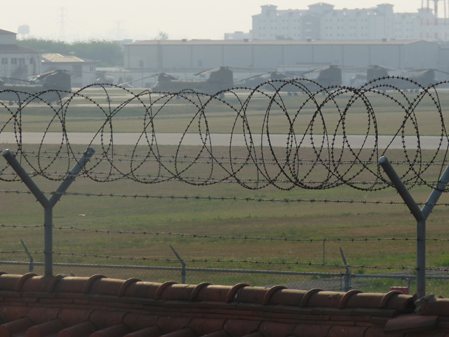 U.S. Army Garrison Humphreys is a helicopter base in what will soon be the the United States' largest overseas military base. Just beyond the fence are small farming villages. (Photo: Jon Letman)