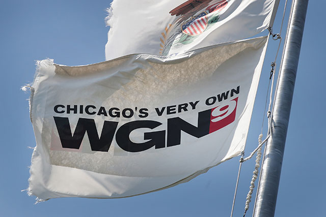 A flag flies outside the studio of Tribune Media Company's WGN television studio on May 8, 2017 in Chicago, Illinois. Tribune Media Co. has agreed to be acquired by Sinclair Broadcast Group for $43.50 per share or about $3.9 billion. Sinclair currently owns 173 Television stations and Tribune 42. (Photo: Scott Olson / Getty Images)