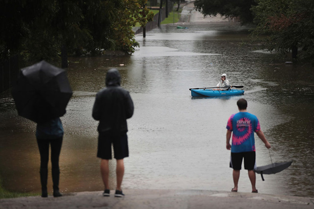 Residents navigate a flooded street that has been inundated with water from Hurricane Harvey on August 27, 2017 in Houston, Texas. Harvey, which made landfall north of Corpus Christi late Friday evening, is expected to dump upwards of 40 inches of rain in areas of Texas over the next couple of days. (Photo: Scott Olson / Getty Images)