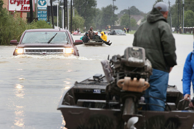  Rescue workers and volunteers help residents make their way out of a flooded neighborhood after it was inundated with rain water following Hurricane Harvey on August 29, 2017 in Houston, Texas. Harvey, which made landfall north of Corpus Christi August 25, has dumped nearly 50 inches of rain in and around areas of Houston. (Photo: Scott Olson / Getty Images)
