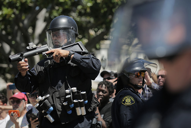 Police with rubber bullet launchers stand guard at MLK Jr. Park on August 27, 2017 in Berkeley, California. The park became a center of left-wing protest when hundreds of people opposed to President Trump and hundreds more aligned with antifa descended on it after a planned right-wing rally was cancelled. (Photo: Elijah Nouvelage / Getty Images)