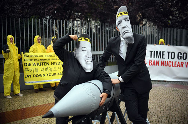 Activists of the non-governmental organization International Campaign to Abolish Nuclear Weapons  wear masks of Donald Trump and leader of the Democratic People's Republic of Korea Kim Jon-un while posing with a mock missile in front of the embassy of Democratic People's Republic of Korea in Berlin, on September 13, 2017. (Photo: Britta Pedersen / AFP / Getty Images)