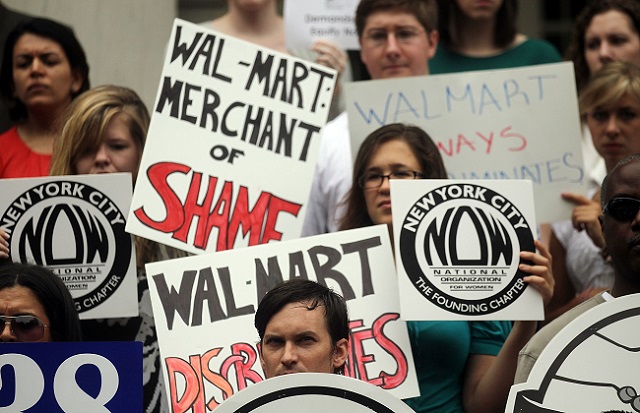 Protesters hold signs during an anti Wal-Mart rally on City Hall steps on June 21, 2011 in New York City. The protesters called on officials to pass fair pay legislation for women following the landmark Dukes vs. Wal-Mart decision. (Photo: Mario Tama / Getty Images)