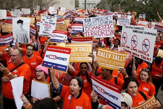 Activists hold up signs at the Florida State Capitol as they rally for gun reform legislation on February 26, 2018 in Tallahassee, Florida. In the wake of the February 14 school shooting that left 17 people dead, hundreds of people joined the Parkland students to call for gun reform. (Photo by Don Juan Moore/Getty Images)