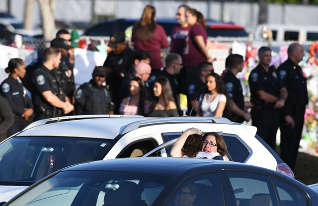 People embrace as students return to Marjory Stoneman Douglas High School on Wednesday February 28, 2018 in Parkland, Florida. A mass shooting on February 14th at the school left 17 people dead. Students returned Wednesday to a half-day of school. (Photo: Matt McClain / The Washington Post via Getty Images)